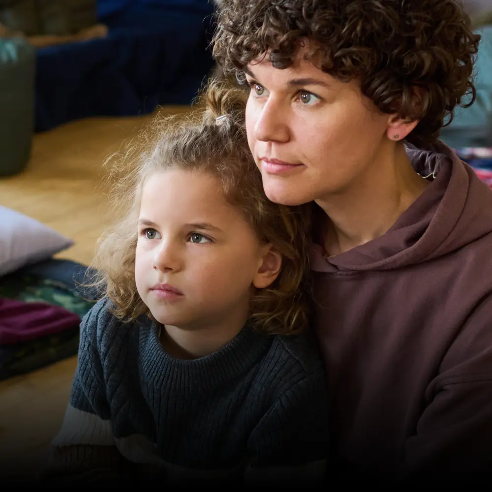 Female refugee sits with her daughter in temporary accommodation.