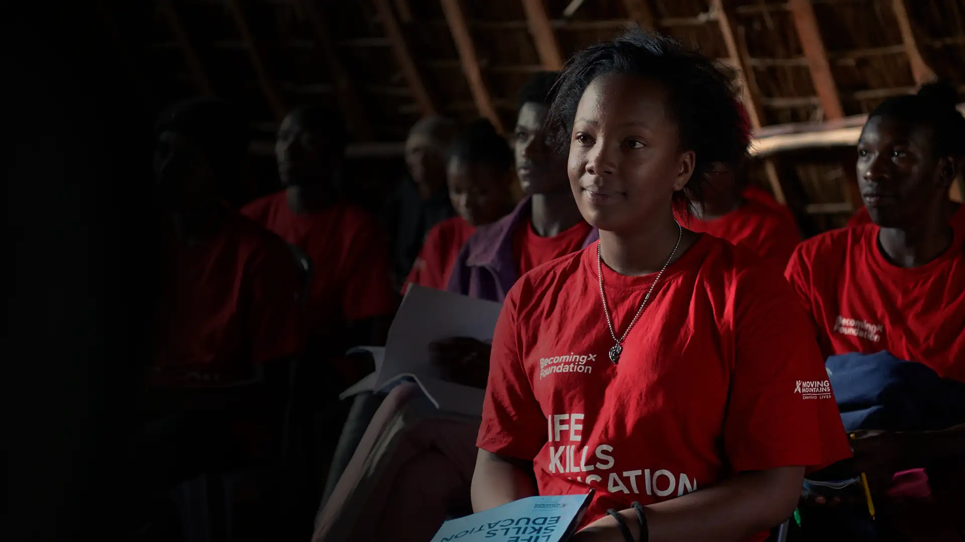 School children in Africa listening to a talk on dealing with adversity, wearing BecomingX Foundation T-shirts.