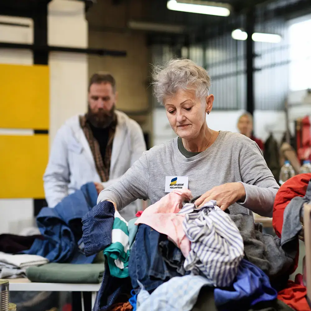 A charity volunteer for Ukrainian refugees helps to sort donated clothes