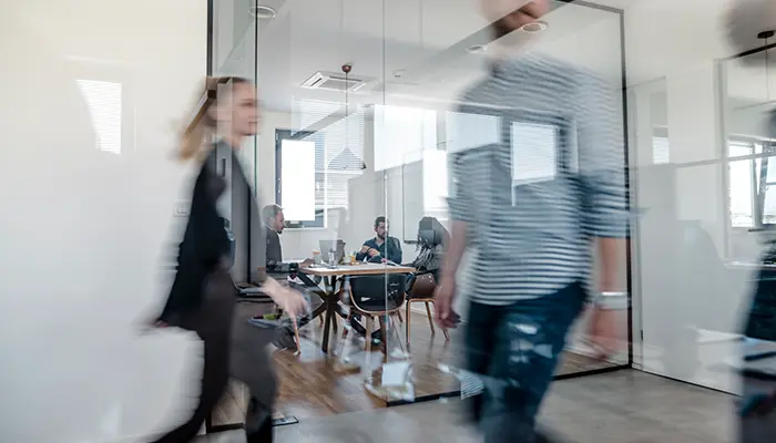 Company staff walking past a meeting room