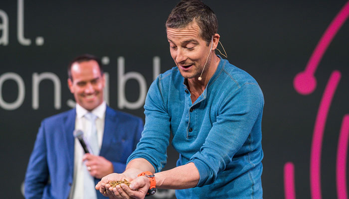 Bear Grylls holding maggots as he appears as a guest speaker at a BecomingX corporate training session.