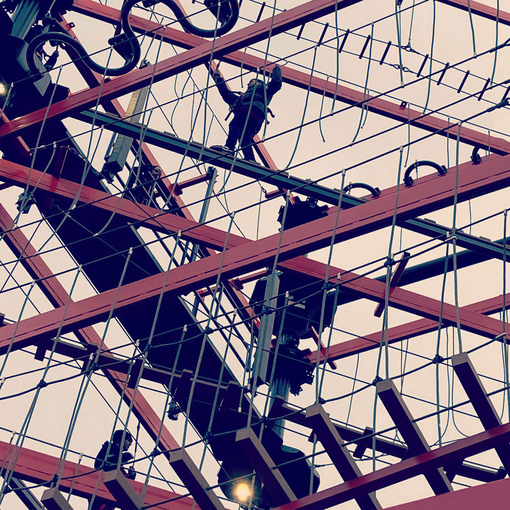 DSW employees working together on the high ropes course at adventure park Bear Grylls Adventure.